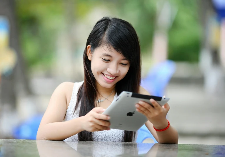 a woman sitting at a table looking at a tablet, pixabay, happening, young cute wan asian face, square, giddy smirk, teen girl