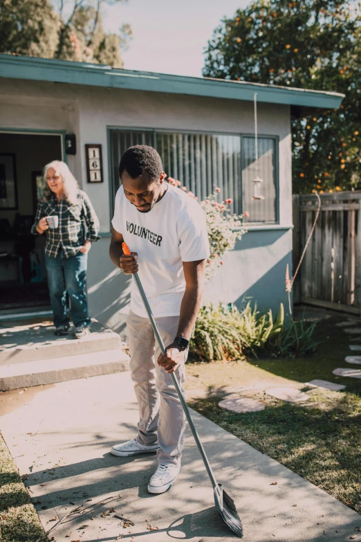 a man cleaning a sidewalk in front of a house, pexels contest winner, happening, young male with walking stick, blind brown man, : kendrick lamar, man and woman walking together