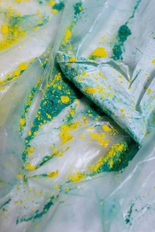 a close up of a plastic bag with food in it, a silk screen, inspired by Lynda Benglis, green and yellow tones, vibrant powder paints, dynamic pearlescent teal light, covered in white flour