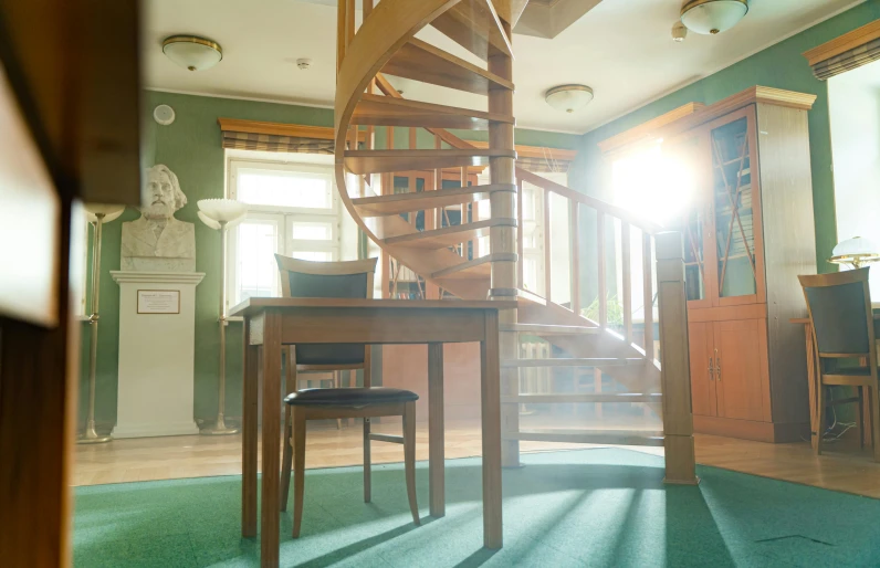 a living room filled with furniture and a spiral staircase, inspired by Constantin Hansen, unsplash, arts and crafts movement, soft green natural light, tallinn, magic library, with the sun shining on it