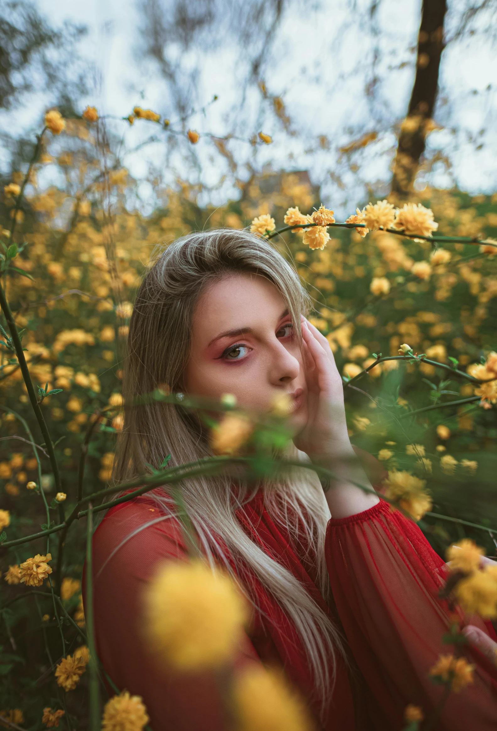 a woman standing in a field of yellow flowers, inspired by Elsa Bleda, aestheticism, blonde, wearing red and yellow clothes, avatar image, looking into camera