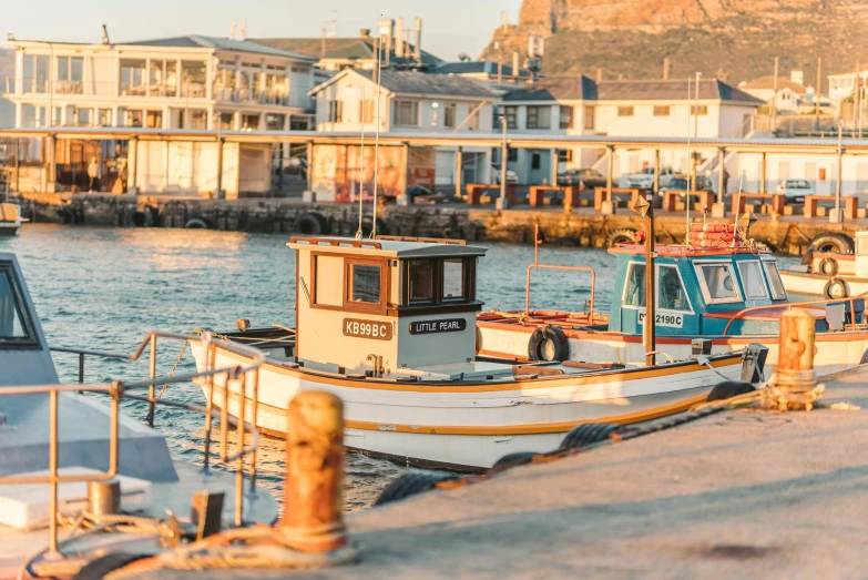 a couple of boats that are sitting in the water, pexels contest winner, south african coast, city docks, warm light, a quaint