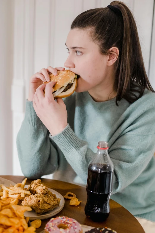 a woman sitting at a table eating a sandwich, trending on pexels, hyperrealism, coke and chips on table, profile image, stomach, drinking cough syrup