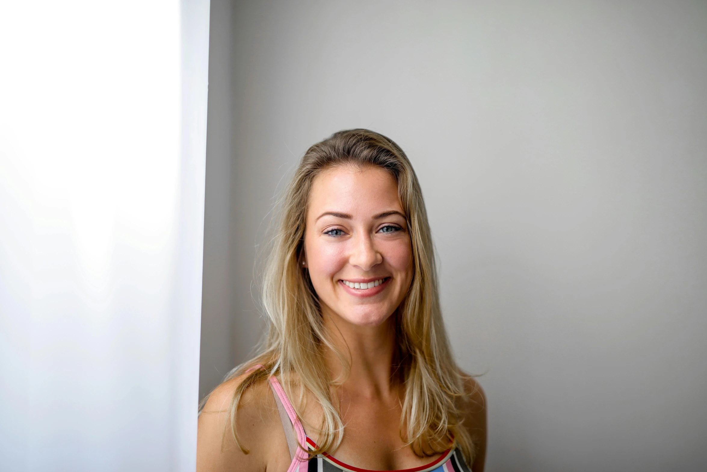 a woman posing for a picture in front of a window, liam brazier, smiling down from above, yoga, profile image