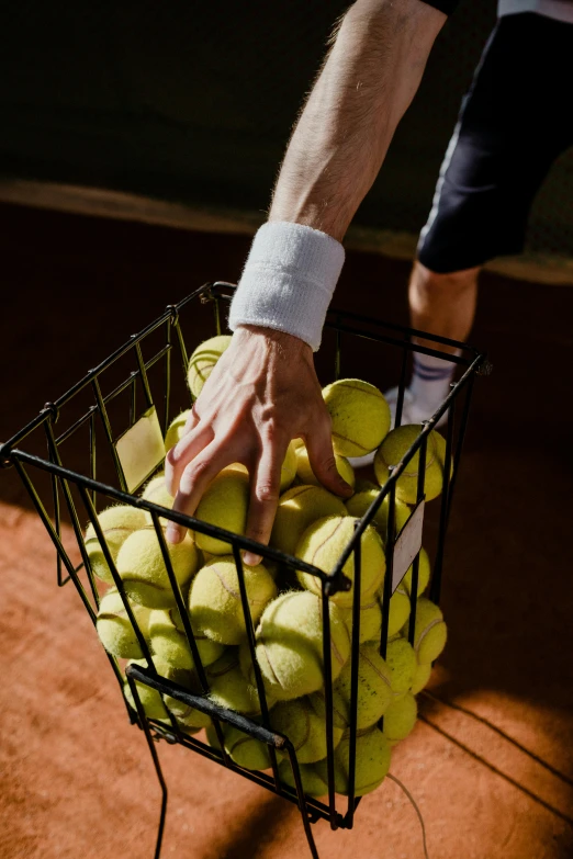 a man holding a basket full of tennis balls, by Jan Tengnagel, unsplash, fist training, rectangle, instagram picture, stacked