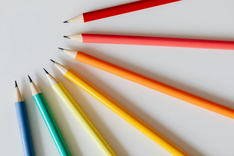 a group of colored pencils arranged in a circle, trending on pexels, on grey background, medium: black pencil, sleek spines, schools