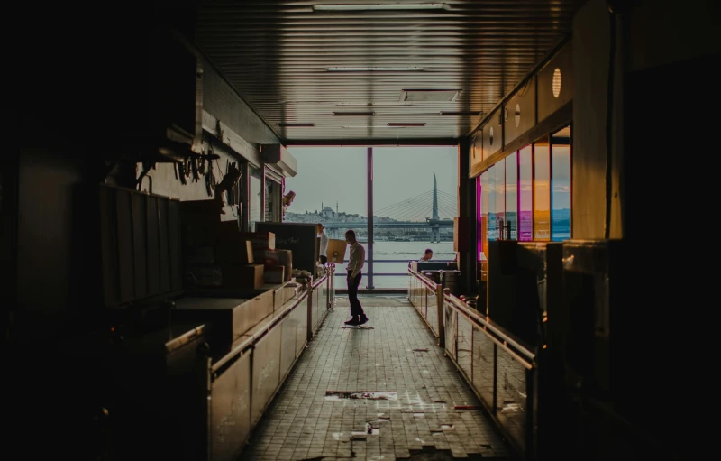 a couple of people that are standing in a hallway, an album cover, pexels contest winner, standing on a ship deck, diner scene, abandoned buildings, unsplash photography