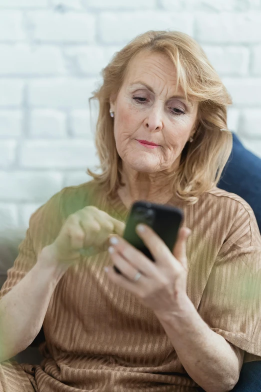 a woman sitting on a couch looking at her cell phone, a portrait, pexels, renaissance, older woman, close up of a blonde woman, square, multiple stories