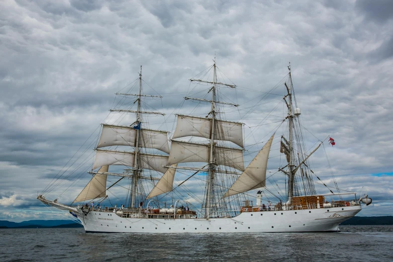 a large white boat floating on top of a body of water, by Ejnar Nielsen, pexels contest winner, arabesque, three masts, navy, sea cloud, performing