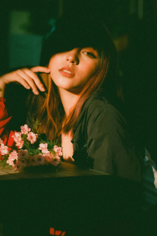 a woman sitting at a table with a cake, an album cover, inspired by Elsa Bleda, unsplash, realism, japanese woman, straight bangs, celestial red flowers vibe, portrait of vanessa morgan
