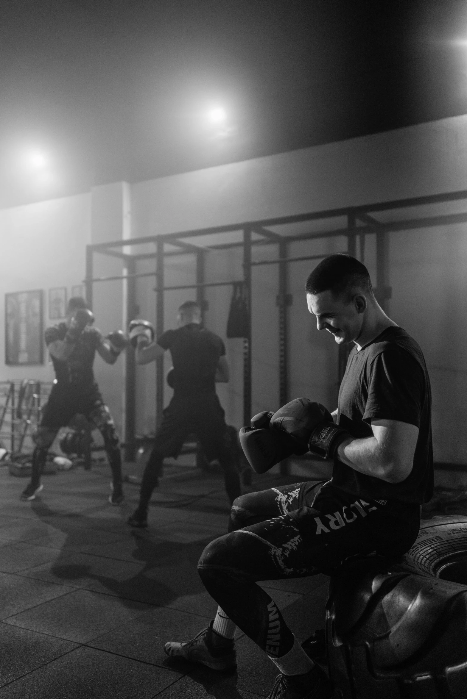 a man sitting on a bench in a gym, a black and white photo, by Adam Marczyński, pexels contest winner, sparring, soldiers charging in, square, programming