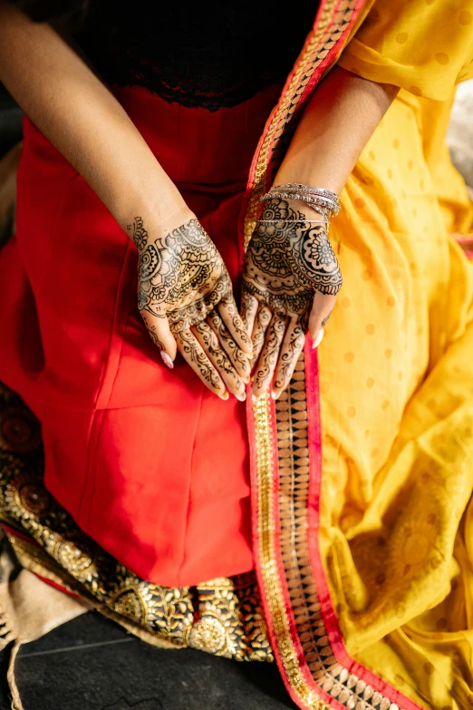 a woman with henna painted on her hands, an album cover, curated collections, intricate silk clothing, detail shot, south east asian with long