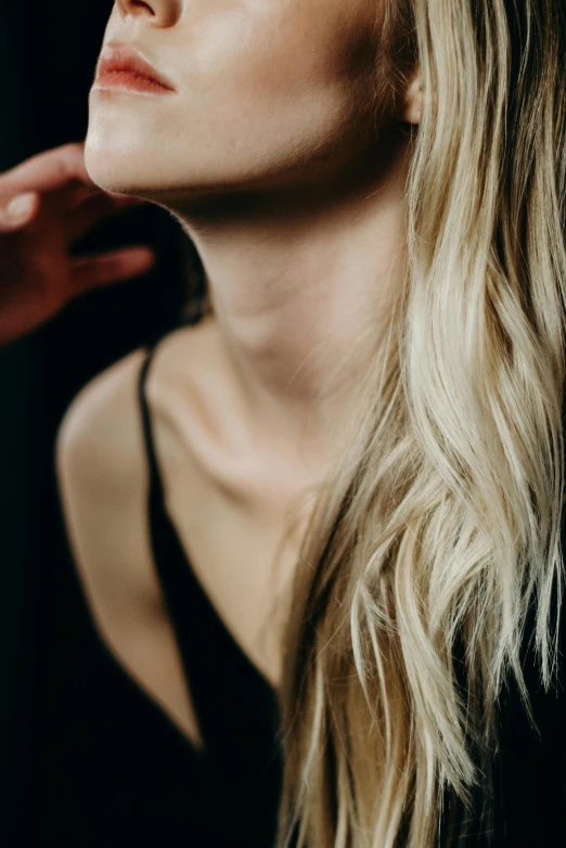 a woman with long blonde hair wearing a black top, trending on pexels, on a young beautiful woman neck, surface blemishes, around a neck, portrait featured on unsplash