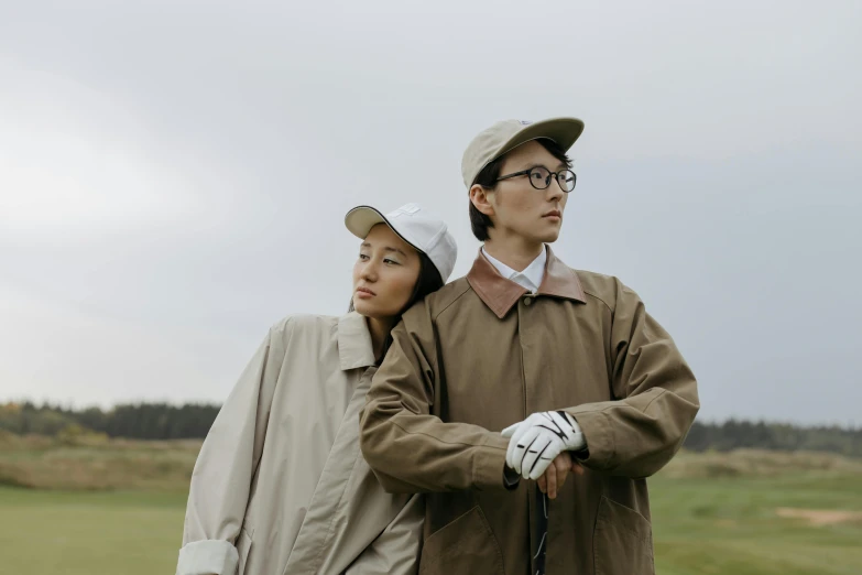 a man and a woman standing next to each other, unsplash, visual art, golf course, wearing trenchcoat, mingchen shen, thumbnail