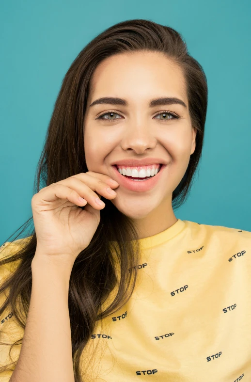 a woman brushing her teeth with a toothbrush, a picture, by Matthias Stom, shutterstock, pop art, wearing a modern yellow tshirt, isabela moner, photoshoot for skincare brand, relaxed. blue background