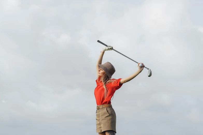 a woman in a red shirt is playing golf, inspired by Shirley Teed, unsplash, happening, an ahoge stands up on her head, girl wearing uniform, giant wooden club, arms raised