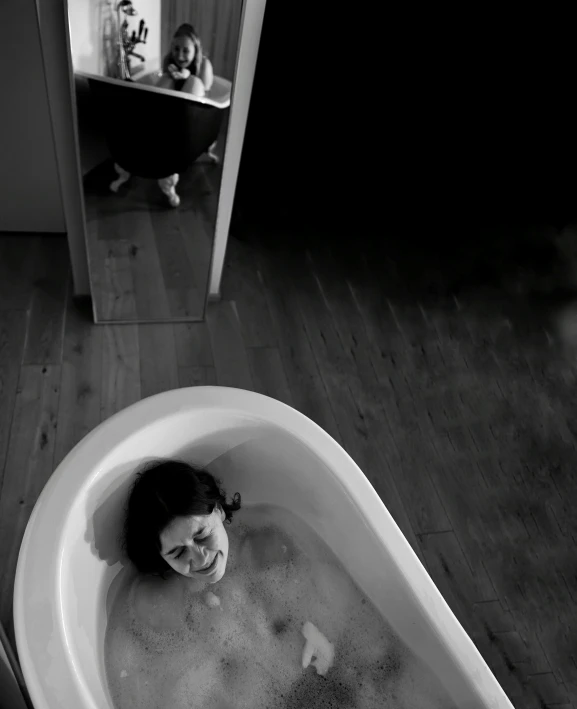 a black and white photo of a woman in a bathtub, a black and white photo, by Lucia Peka, making of, :: morning, birth, humorous