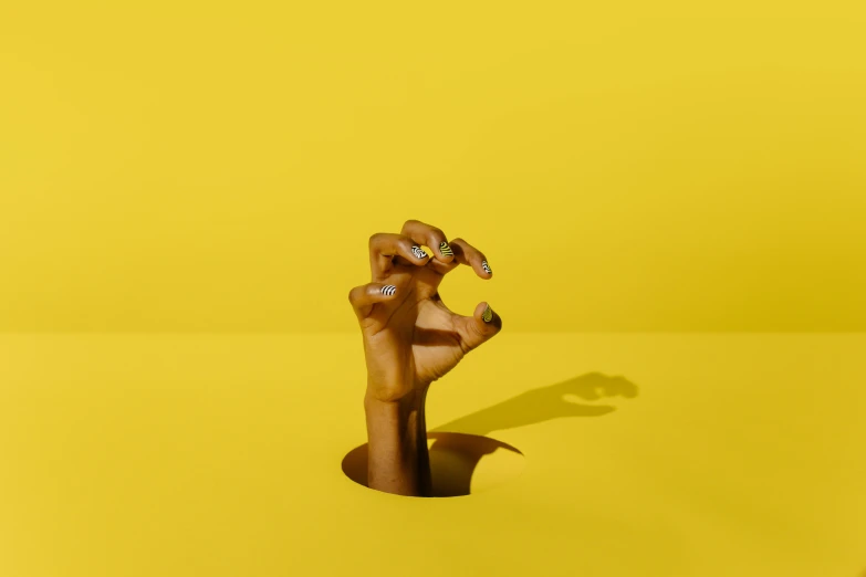 a toy giraffe standing on top of a yellow surface, an album cover, inspired by Robert Mapplethorpe, trending on pexels, hyperrealism, photo of a hand jewellery model, wolfy nail, abstract holescape, aida muluneh