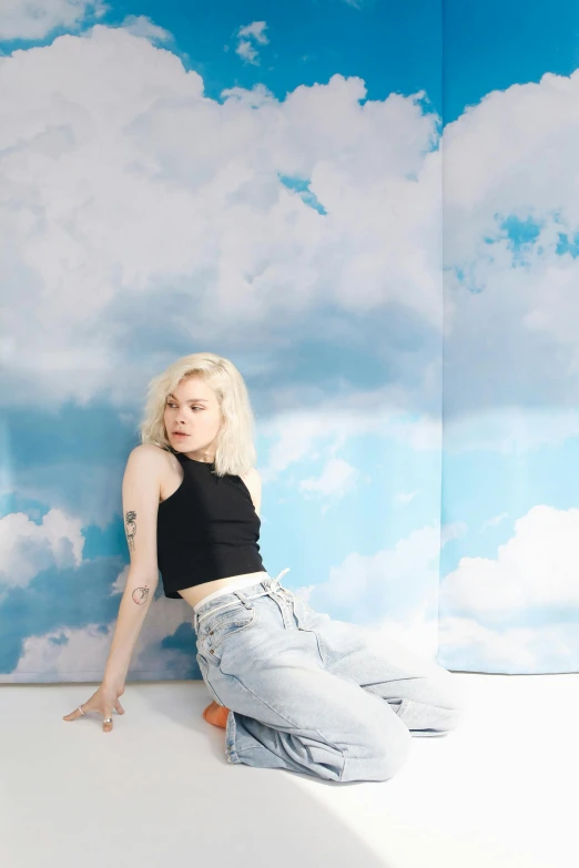 a woman sitting on top of a white floor, an album cover, inspired by Elsa Bleda, trending on pexels, tattoos of cumulus clouds, elle fanning), jeans, sky mural on the room ceiling