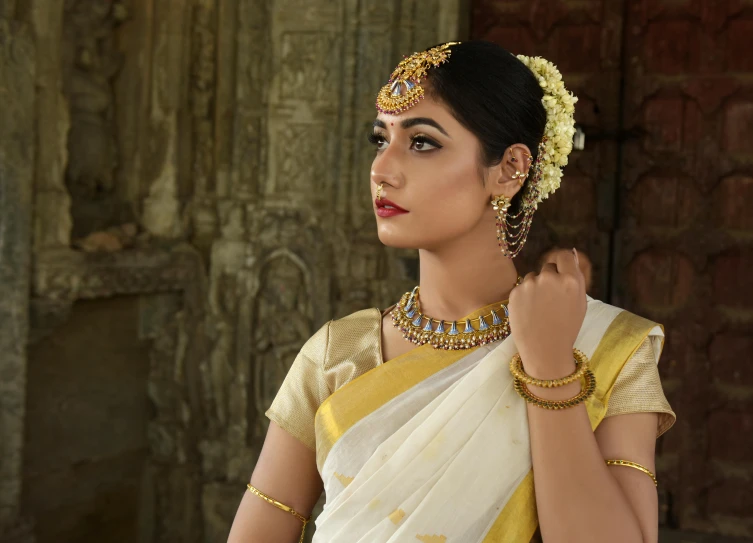 a woman in a white and yellow sari, a portrait, inspired by Raja Ravi Varma, trending on cg society, wearing jewellery, movie still 8 k, temple, promo image