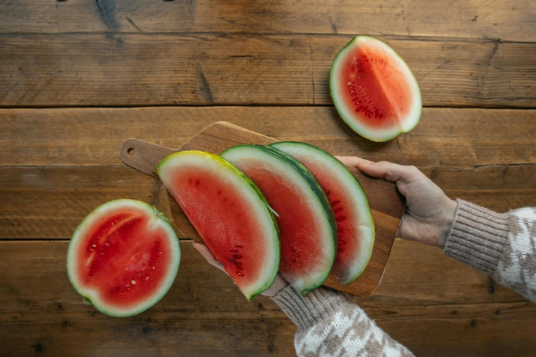 a person cutting up slices of watermelon on a cutting board, an album cover, by Julia Pishtar, pexels contest winner, hurufiyya, partially cupping her hands, 6 pack, vertical orientation, seasonal