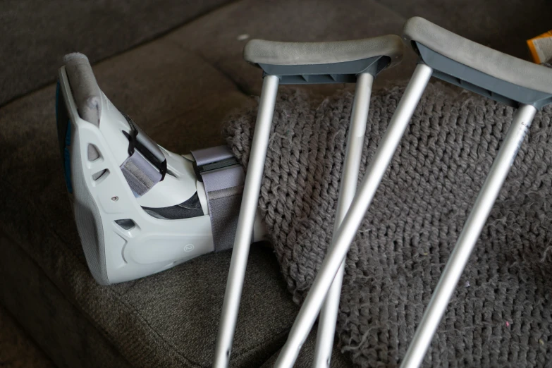 a pair of crutches sitting on top of a couch, pexels, hyperrealism, sneaker photo, covered in bandages, white, wearing boots