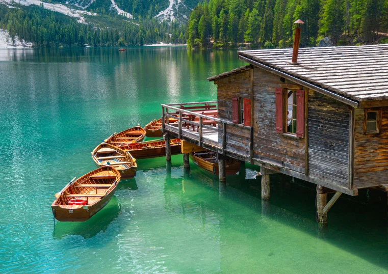 a group of boats that are sitting in the water, by Julia Pishtar, pexels contest winner, chalet, vouge italy, green waters, wooden banks