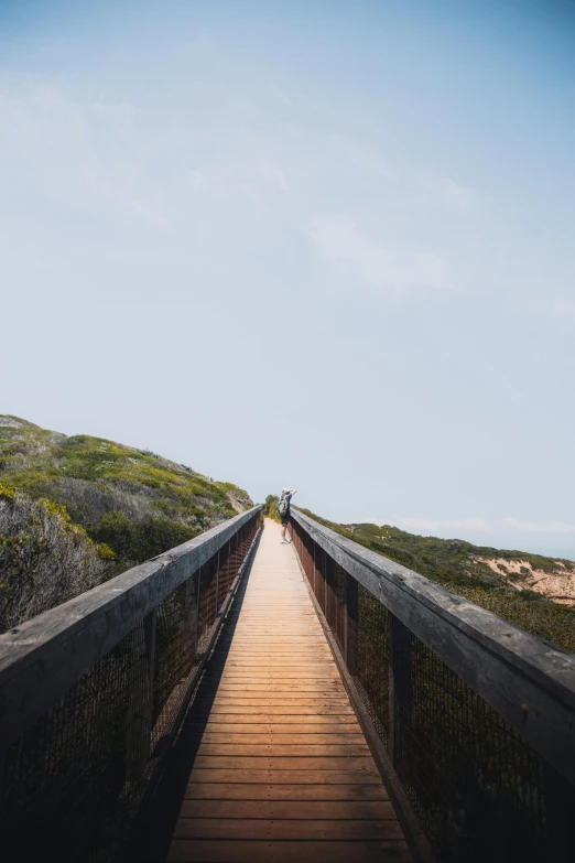 a wooden bridge over a body of water, by Lee Loughridge, unsplash, australian beach, top of a canyon, dune, long hall way