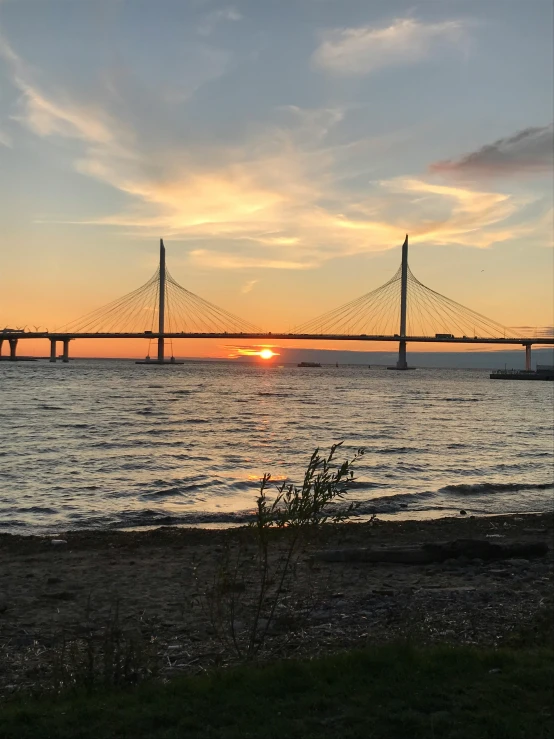 a sunset over a body of water with a bridge in the background, annato finnstark, notan sun in the background, upon a peak in darien, lots of bridges