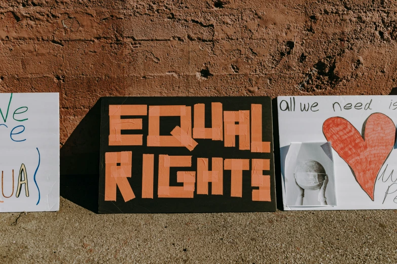 a couple of signs sitting on top of a sidewalk, an album cover, trending on unsplash, feminist art, election poster, white and orange breastplate, protest, eight eight eight