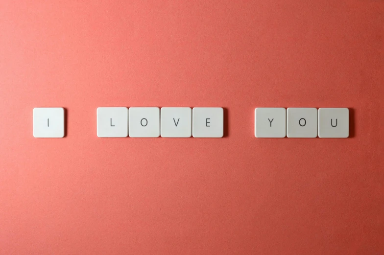 the word i love you spelled in white tiles on a pink background, a picture, by Emma Andijewska, pexels, letterism, gray and orange colours, profile picture, squares, skincare