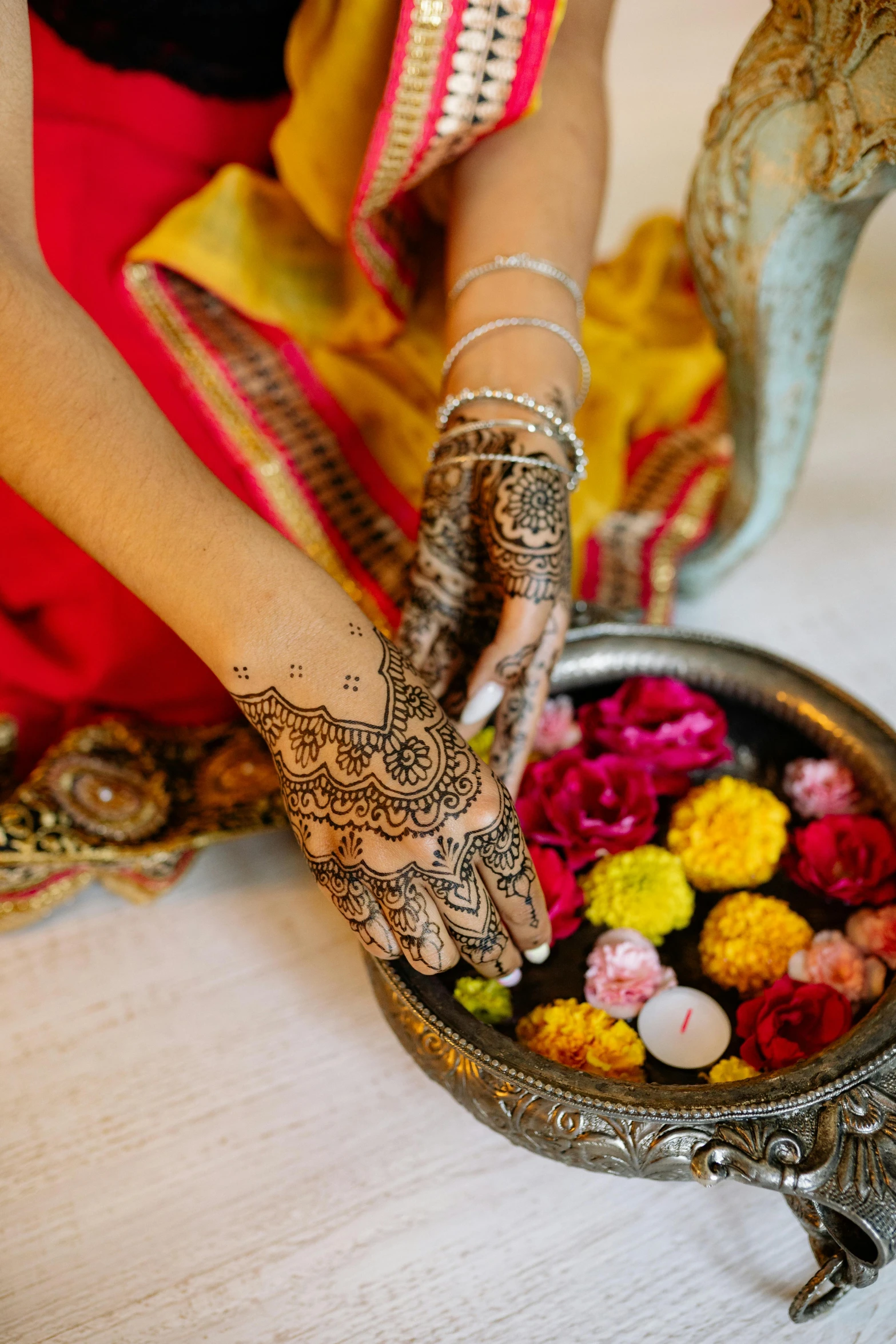 a woman is putting henna on her hands, by Dan Content, trending on unsplash, with yellow flowers around it, wedding, multicoloured, full length shot