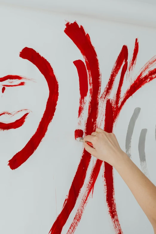 a woman is painting on a wall with red paint, inspired by Francesco Clemente, trending on pexels, action painting, white red, ( ( brush stroke ) ), on grey background, portrait made of paint