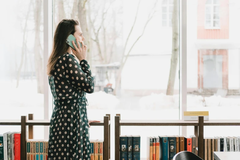 a woman standing in front of a window talking on a cell phone, the librarian, promo image, jovana rikalo, patterned