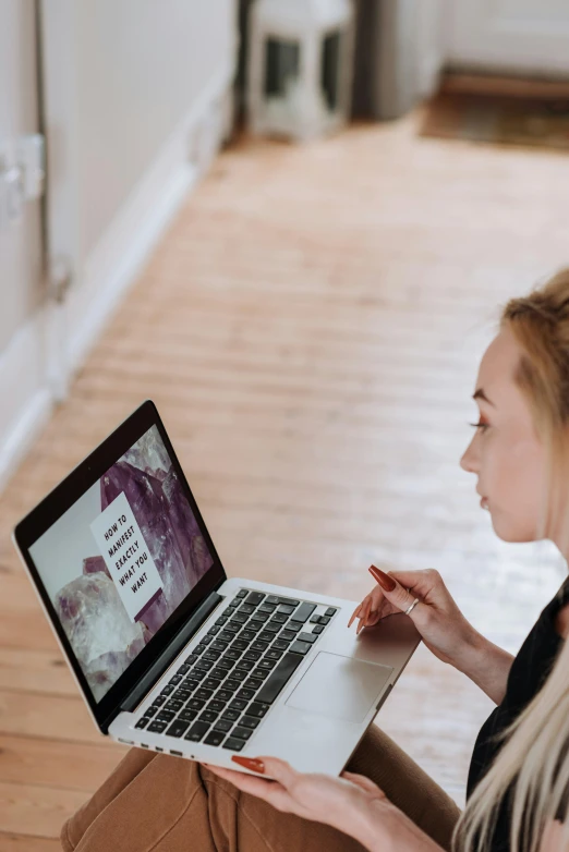 a woman sitting on the floor using a laptop, by Arabella Rankin, trending on pexels, looking from shoulder, with detailed, prompt young woman, 🦑 design