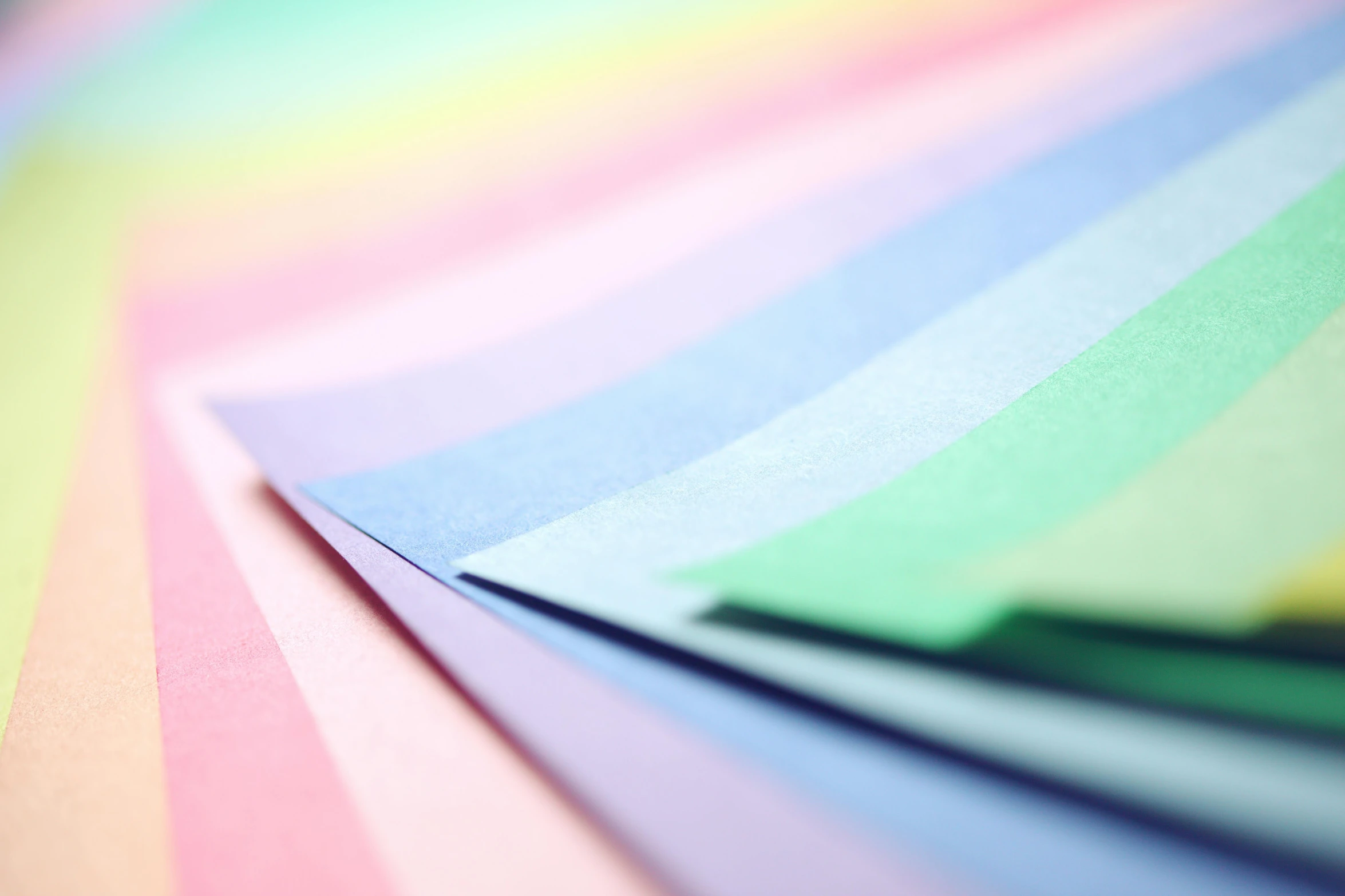 a pile of colored paper sitting on top of a table, by Rachel Reckitt, unsplash, cool tone pastel rainbow colors, multiple stories, medium close up shot, paper craft