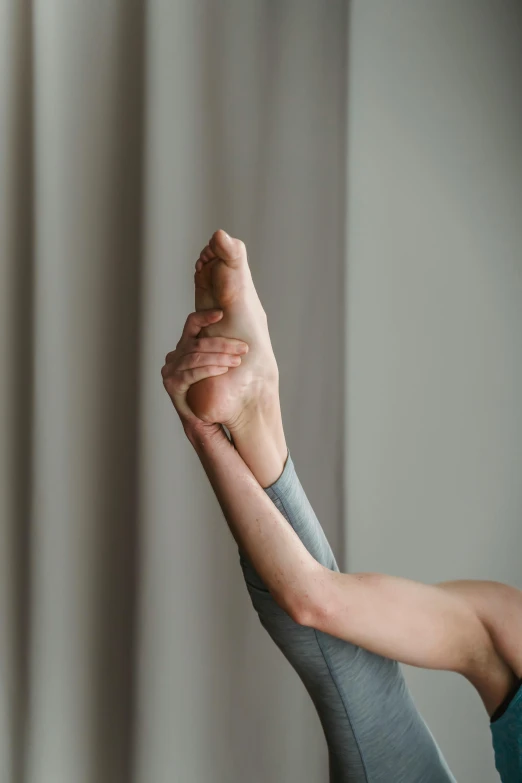 a woman doing a yoga pose in front of a window, by Adam Marczyński, pexels contest winner, renaissance, foot wraps, doing a thumb up, on a gray background, wrinkled muscles skin