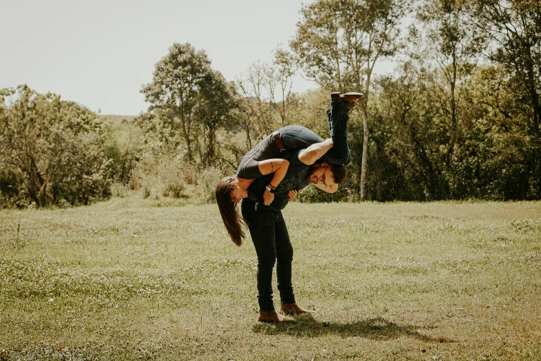 a woman doing a handstand in a field, by Jessie Algie, pexels contest winner, couple kissing, plain background, background image, best friends