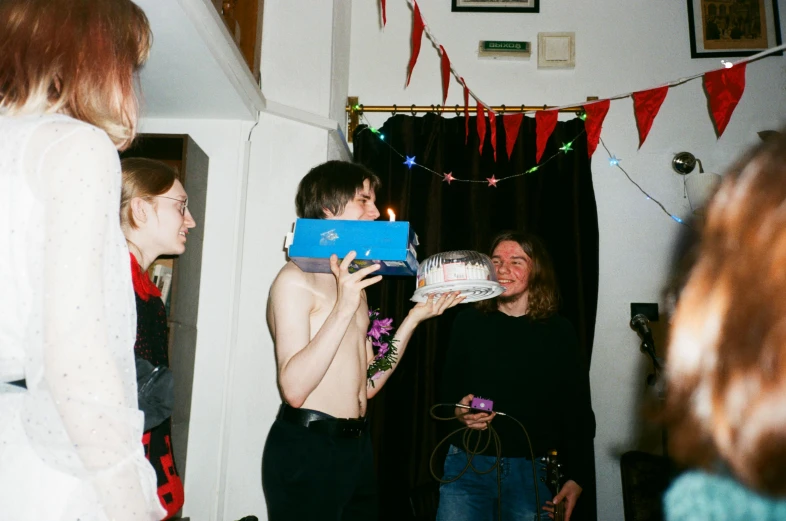 a group of people that are standing in a room, an album cover, inspired by Nan Goldin, tumblr contest winner, purism, holding a birthday cake, giving gifts to people, with pale skin, high quality photo