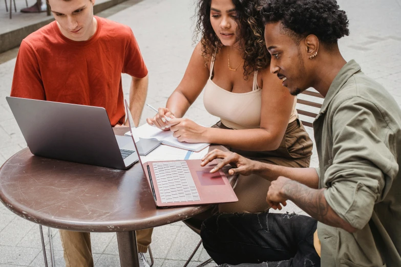 a group of people sitting around a table with laptops, by Carey Morris, pexels contest winner, college students, holding notebook, thumbnail, brown