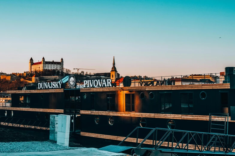 a boat sitting on top of a river next to a bridge, jovana rikalo, viking palace, in the golden hour, 🚿🗝📝