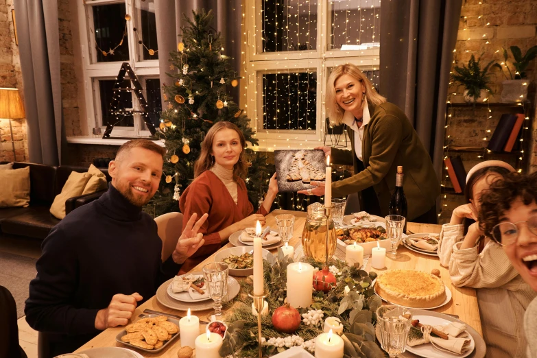 a group of people sitting around a dinner table, christmas, background image, aleksandra waliszewska, guide