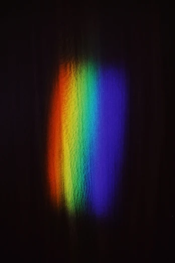 a close up of a rainbow light on a wall, an album cover, inspired by Gabriel Dawe, unsplash, light and space, grainy photograph, dark image, simple chromatic xray, 2010s