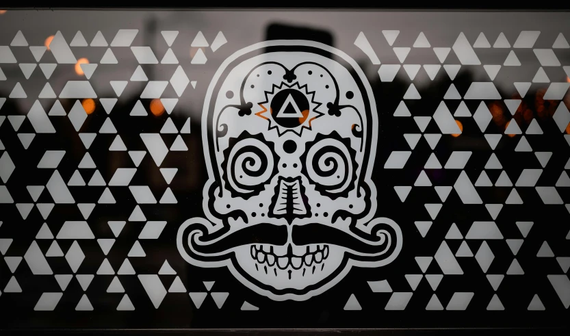 a black and white picture of a skull with a mustache, vector art, inspired by Alejandro Obregón, pexels contest winner, graffiti, on a stained glass window, geometric third eye triangle, shop front, on a black wall