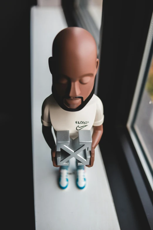 a figurine of a man sitting on a window sill, virgil abloh, wearing nike air mags, signed, view is centered on the robot