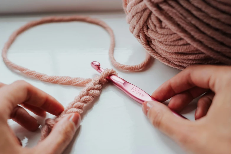 a close up of a person holding a pair of scissors, crochet, pink hues, thumbnail, lots de details