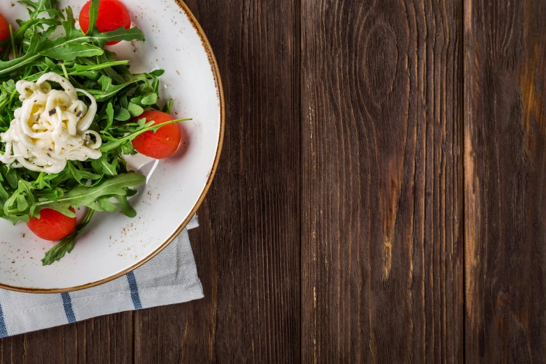 a close up of a plate of food on a table, pexels, realism, background image, 9 9 designs, salad, on a wooden desk