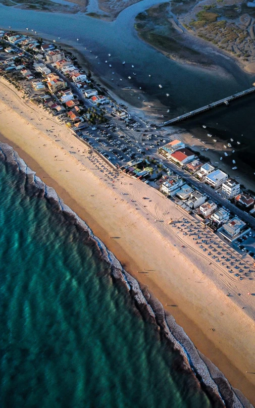 a large body of water next to a sandy beach, by Julian Allen, pexels contest winner, renaissance, fishing town, airborne view, slide show, thumbnail