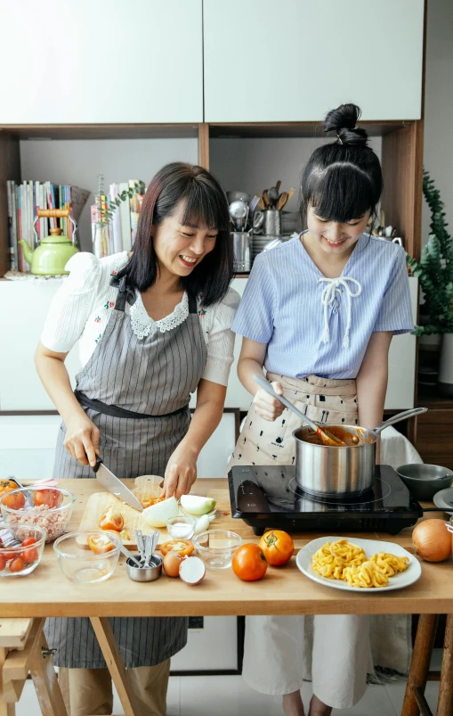 two women in aprons preparing food in a kitchen, a picture, inspired by Miyagawa Chōshun, pexels, promotional image, panoramic view of girl, good housekeeping, pot