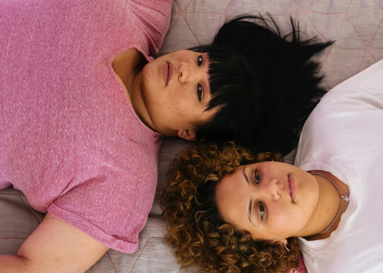 a couple of women laying on top of a bed, inspired by Nan Goldin, pexels, plus-sized, headshot, rectangle, topdown